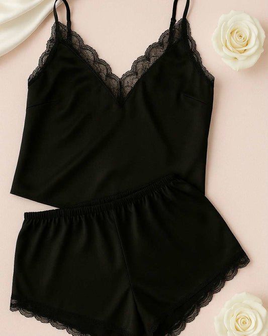 Black lace-trimmed pajama set on a light pink background with white roses.