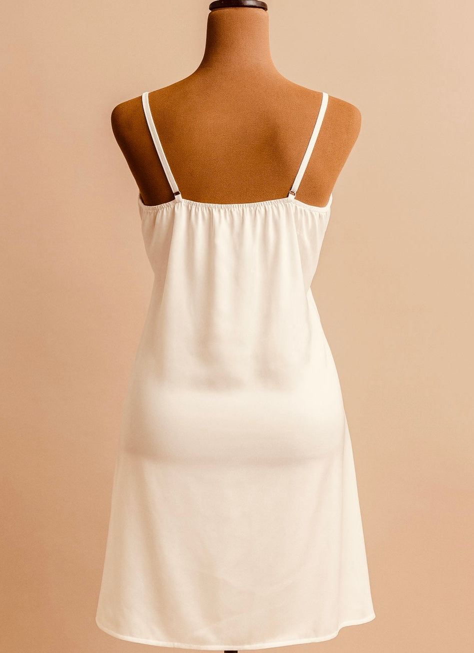 White chemise on a mannequin against a beige background