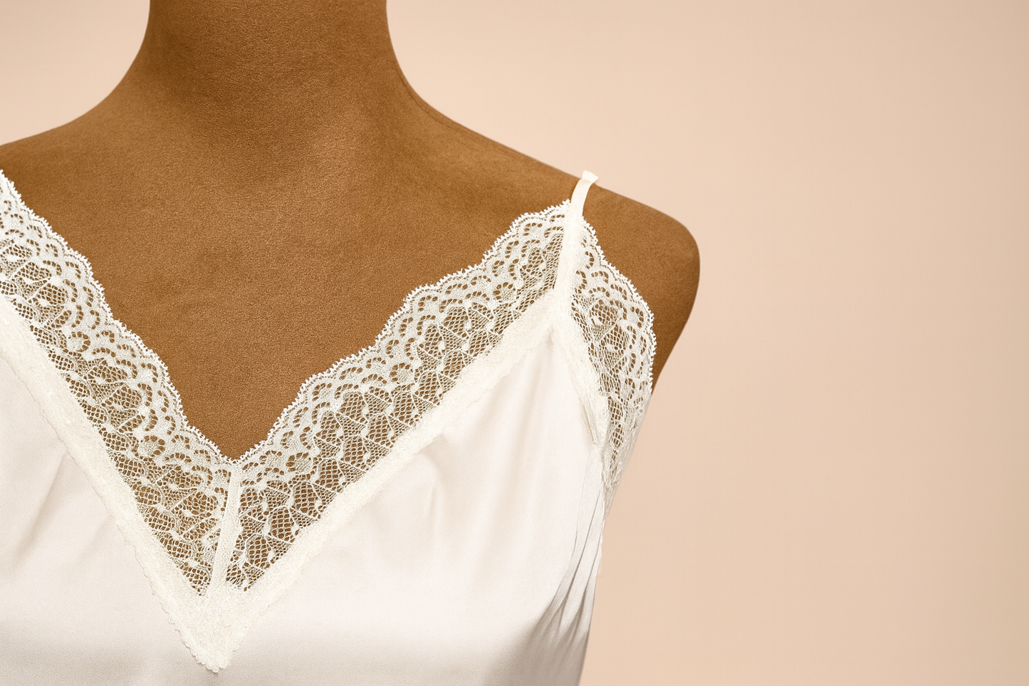 White lace-trimmed top on a mannequin against a beige background