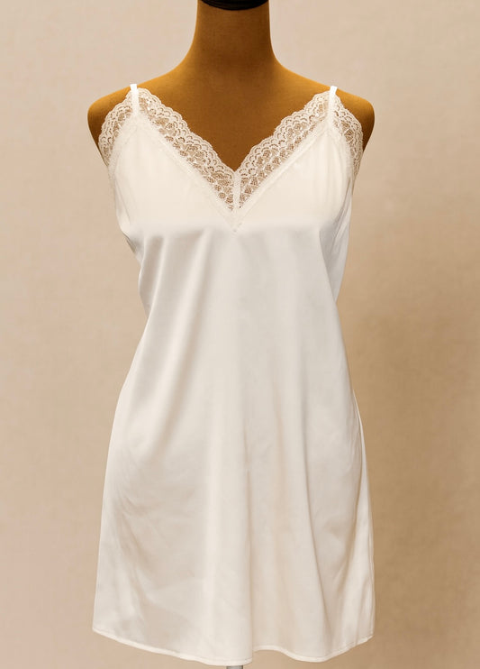 White satin chemise with lace trim on a mannequin against a beige background
