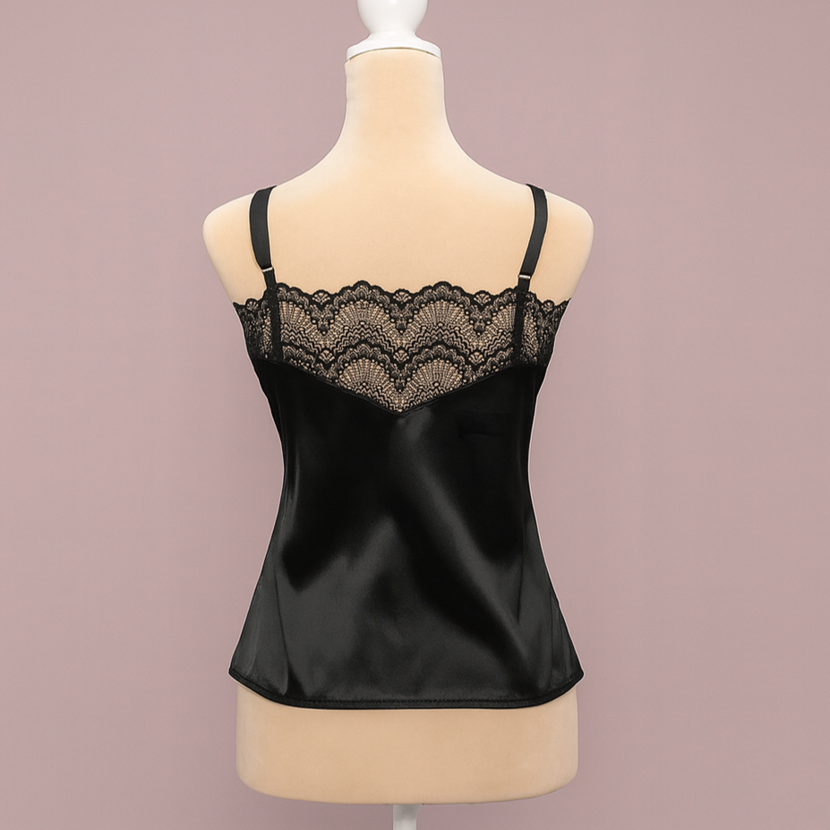 Black satin camisole with lace trim on a mannequin against a pink background