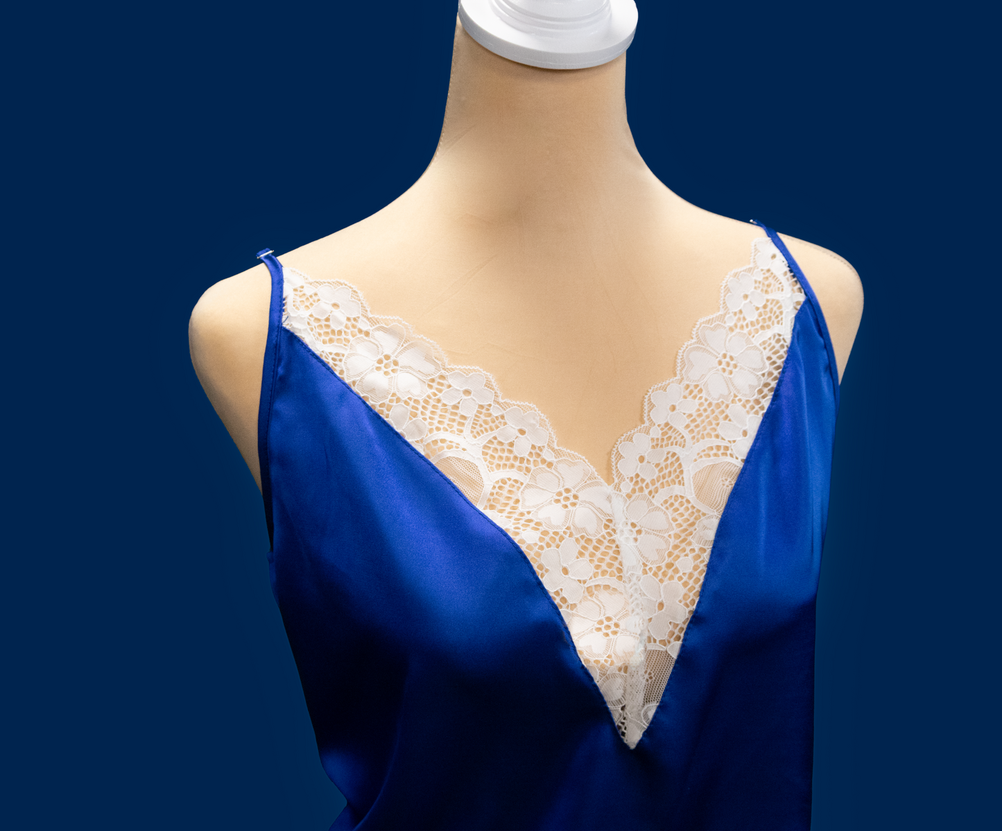 Blue satin set with lace trim on a mannequin against a dark blue background