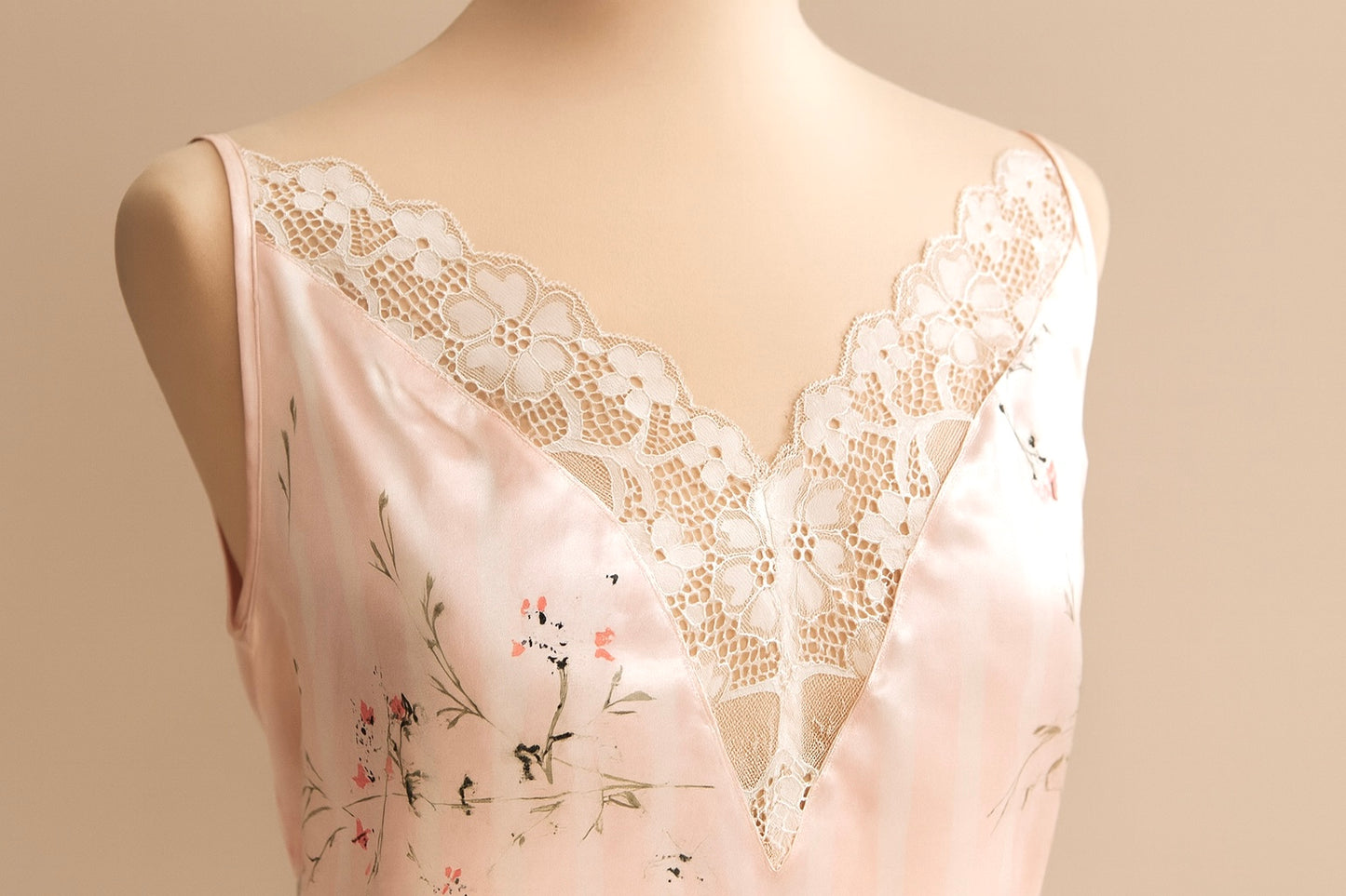 Lace-trimmed pink cami on a mannequin against a beige background