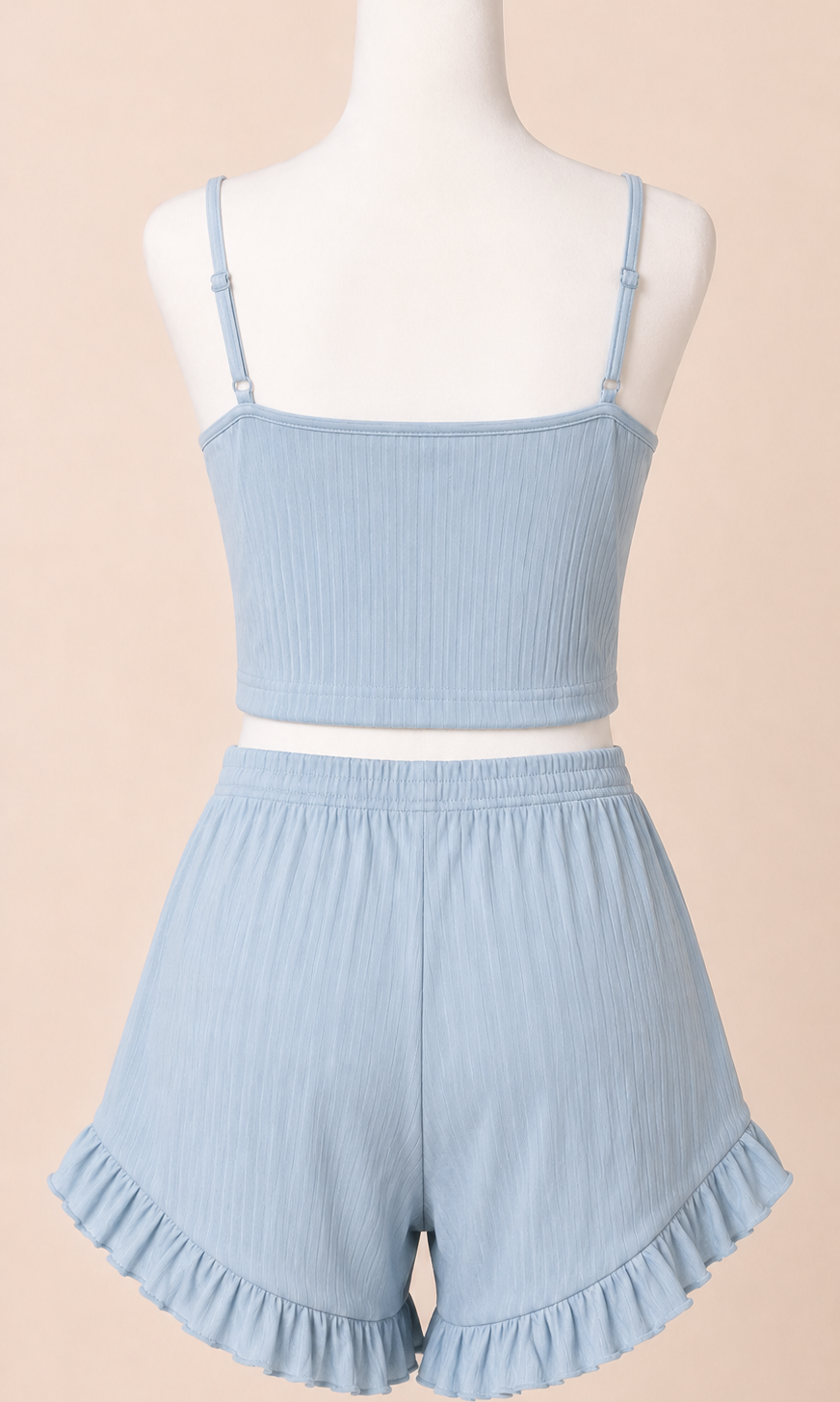 Light blue ruffled top and shorts set on a mannequin against a beige background
