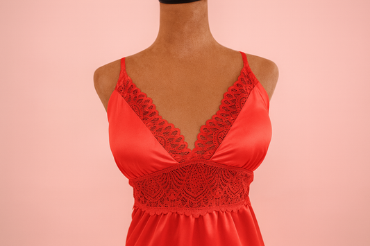 Red lace dress on a mannequin against a pink background