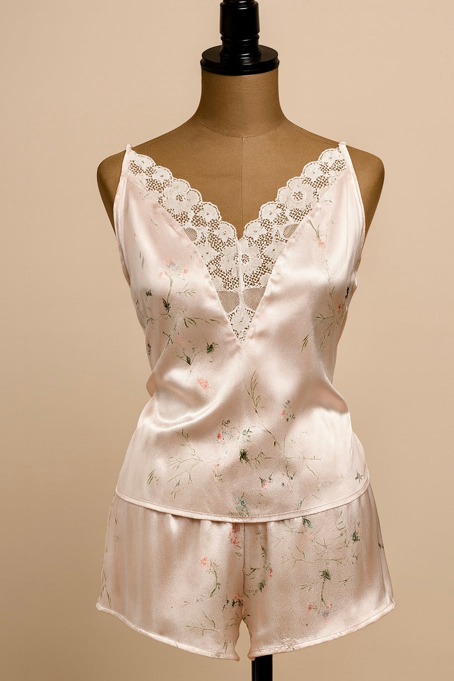 Silk pajama set with lace top and floral shorts on a mannequin against a beige background