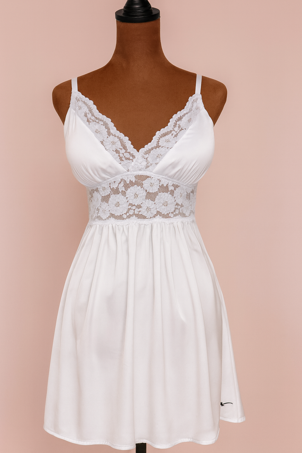 White lace babydoll dress on a mannequin against a pink background Dainty Lace Lingerie